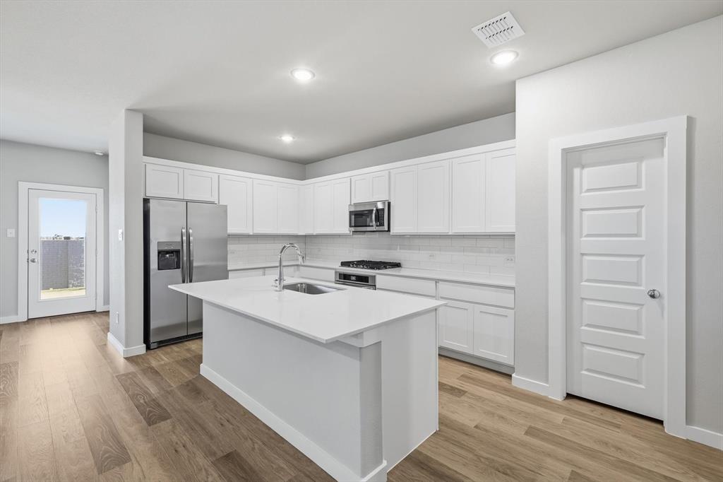 14908 Dust Storm Trail Haslet, TX 76052 - Photo 3 of 20 a kitchen with a sink stove and refrigerator