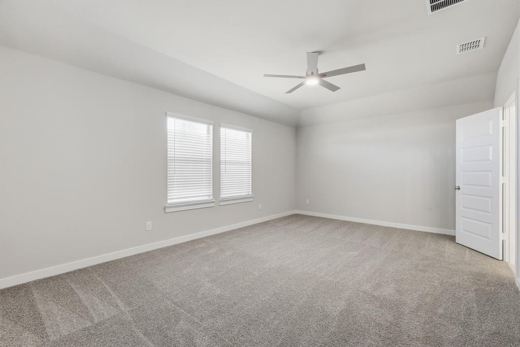 14908 Dust Storm Trail Haslet, TX 76052 - Photo 8 of 20 an empty room with a window and ceiling fan