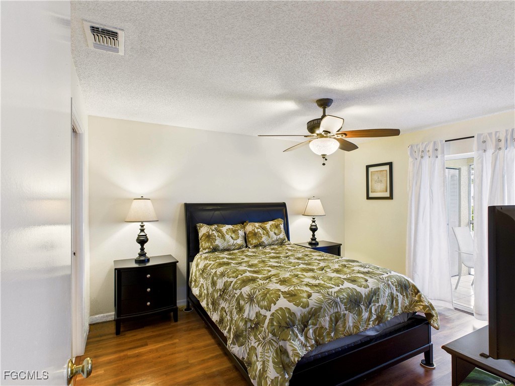 1290 Yesica Ann Circle, Unit G204 Naples, FL 34110 - Photo 14 of 21 a bedroom with a bed and a chandelier