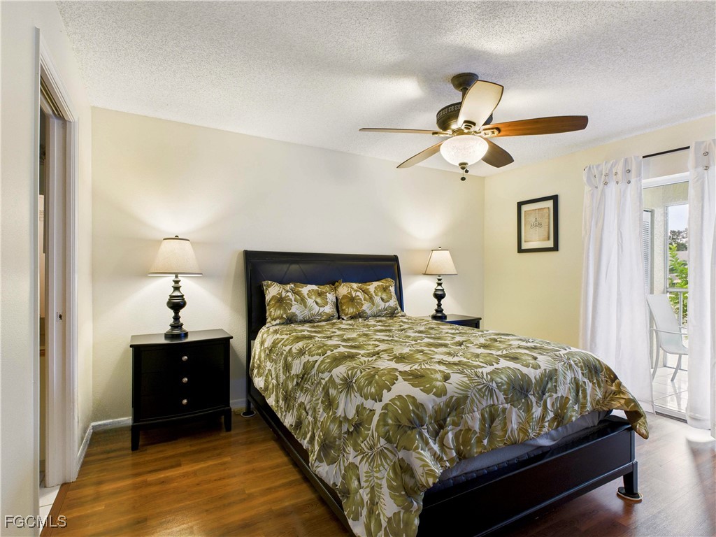 1290 Yesica Ann Circle, Unit G204 Naples, FL 34110 - Photo 18 of 21 a bedroom with a bed and a chandelier