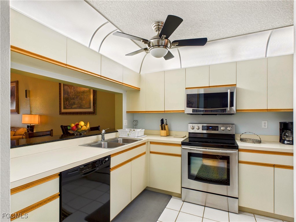 1290 Yesica Ann Circle, Unit G204 Naples, FL 34110 - Photo 3 of 21 a kitchen with a sink a stove and microwave