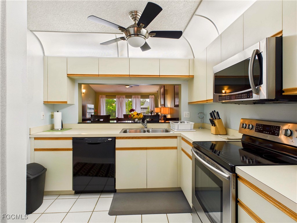 1290 Yesica Ann Circle, Unit G204 Naples, FL 34110 - Photo 4 of 21 a kitchen with a sink a microwave and cabinets
