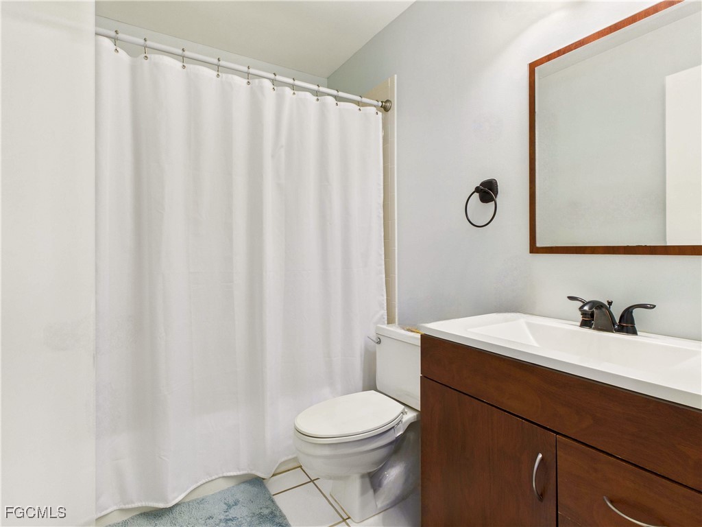1290 Yesica Ann Circle, Unit G204 Naples, FL 34110 - Photo 6 of 21 a bathroom with a sink a toilet and a mirror