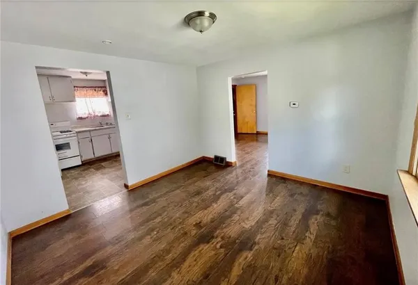a view of empty room with a window and wooden floor