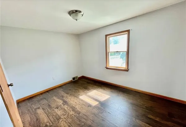 a view of a room with wooden floor and window