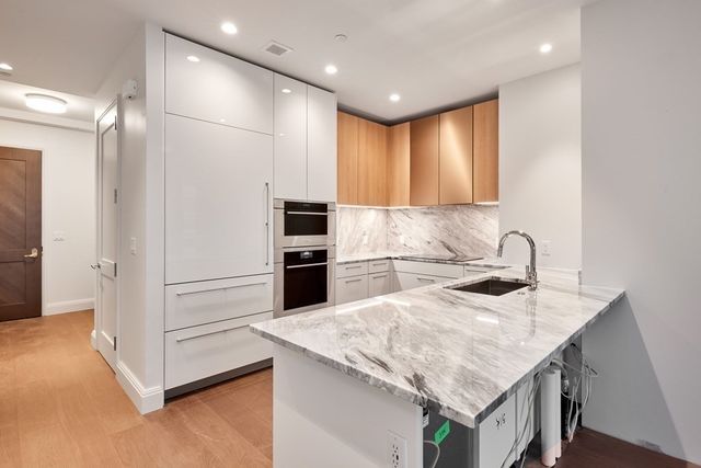 a kitchen with granite countertop a sink appliances and cabinets
