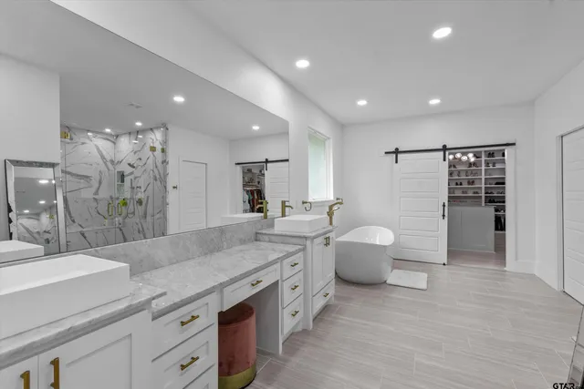 a spacious bathroom with a double vanity sink toilet and a tub