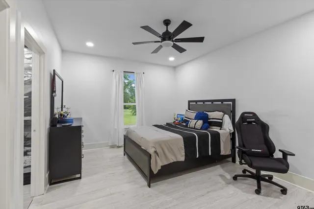 a bedroom with a bed and a ceiling fan