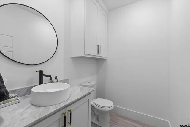 a bathroom with a granite countertop sink and a mirror