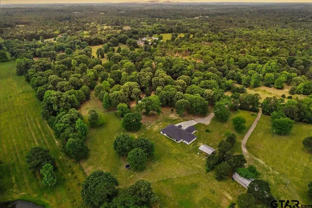 an aerial view of residential house with swimming pool and lawn chairs
