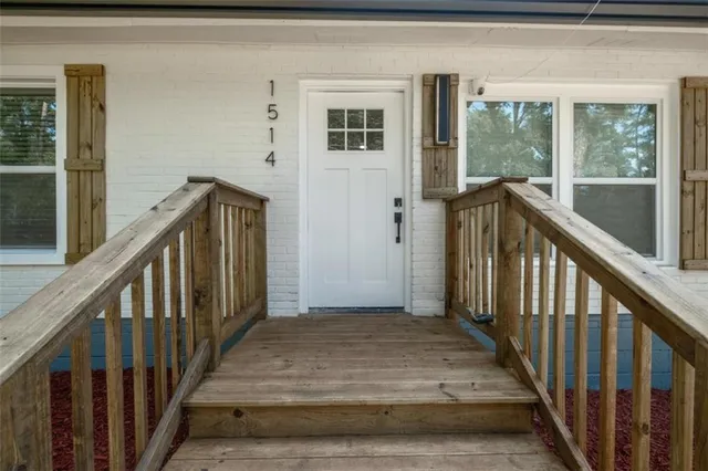 a view of a hallway with wooden floor and stairs