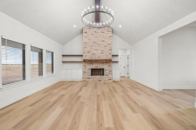 a view of an empty room with a fireplace and window