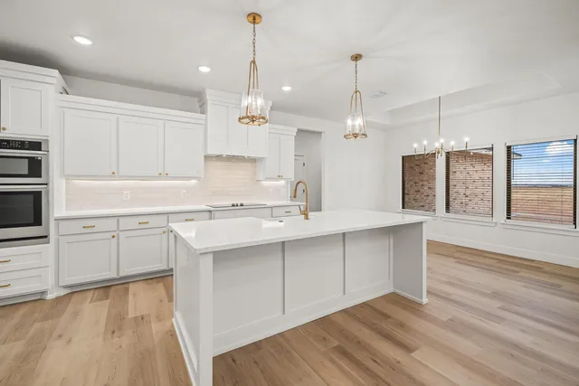 a kitchen with kitchen island granite countertop a sink a center island and cabinets
