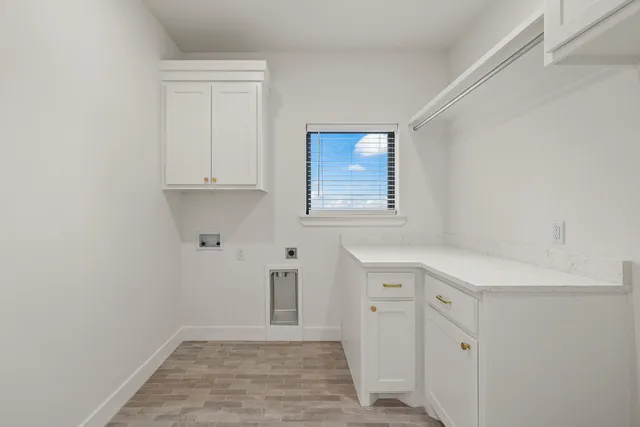 a view of cabinets and utility room with window