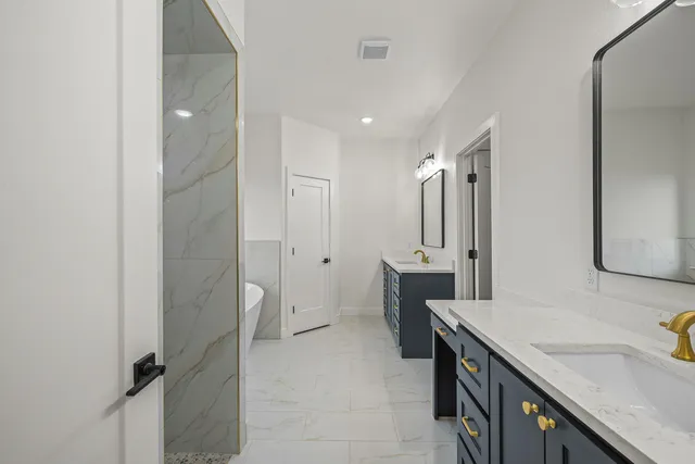 a spacious bathroom with a double vanity sink a mirror and a shower