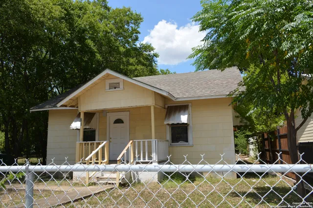 front view of a house with a chairs and table in a patio