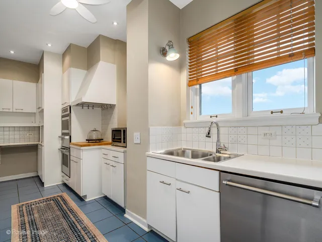a kitchen with white cabinets and appliances
