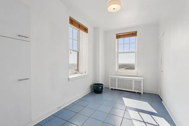 a view of an empty room with window and a bathroom