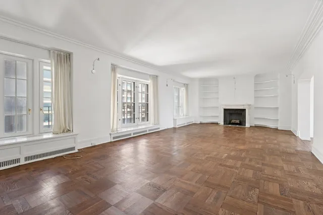 a view of an empty room with a fireplace and a window