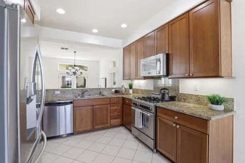 a kitchen with stainless steel appliances granite countertop a stove sink and cabinets