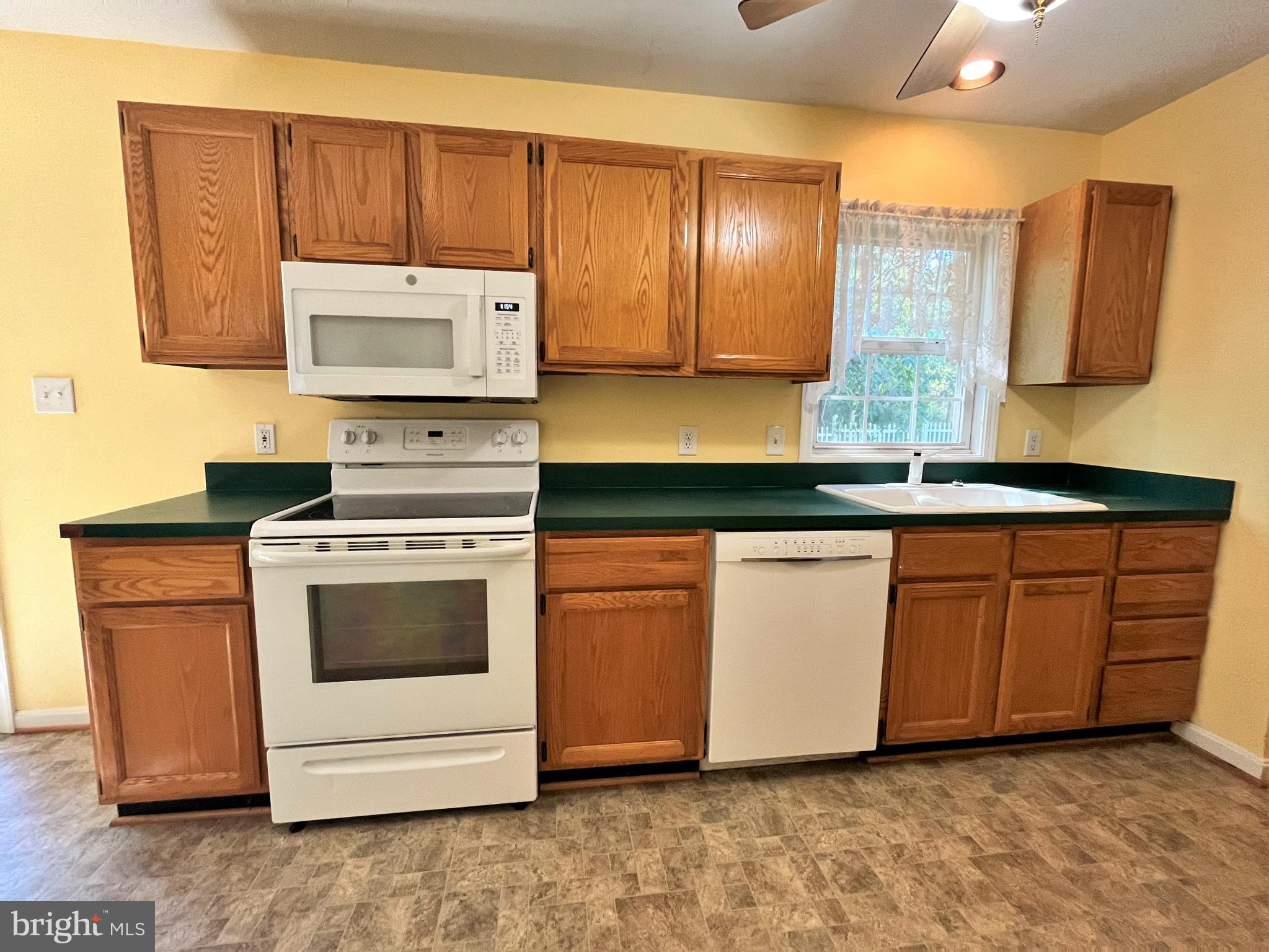 157 Cove Point Road Lusby, MD 20657 - Photo 4 of 19 a kitchen with granite countertop wooden cabinets and white appliances