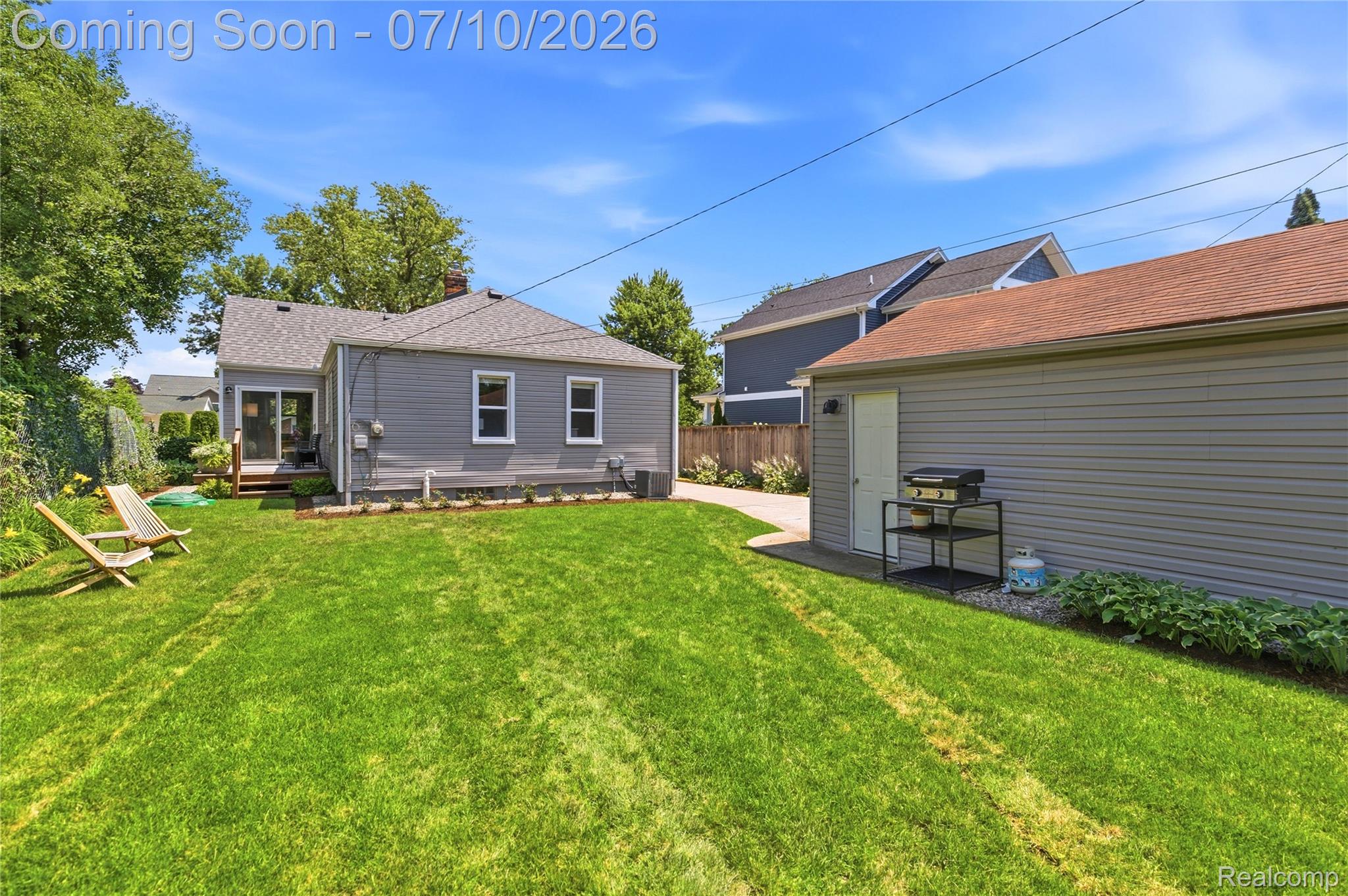 3295 Cumberland Road Berkley, MI 48072 - Photo 27 of 32 Expansive green lawn with a detached garage featuring light gray siding and a brown shingle roof