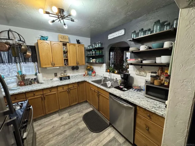 a kitchen with stainless steel appliances granite countertop a sink a stove and cabinets