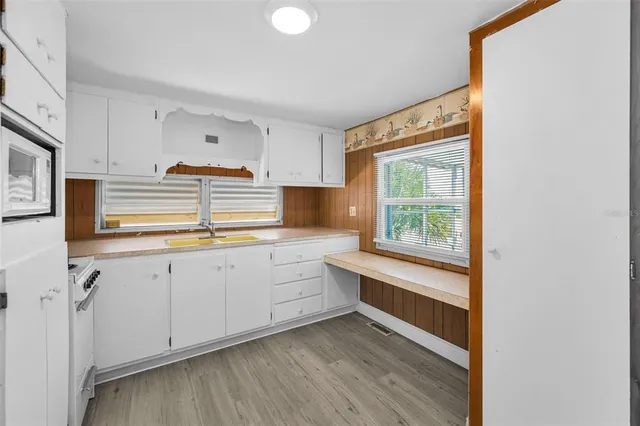 a kitchen with granite countertop white cabinets and white appliances