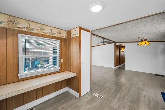 a view of hallway with wooden floor and windows