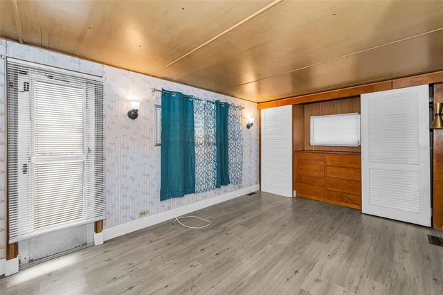 an empty room with wooden floor and doors