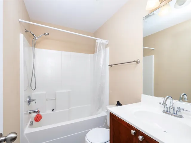 a bathroom with a sink vanity granite tub shower and a mirror