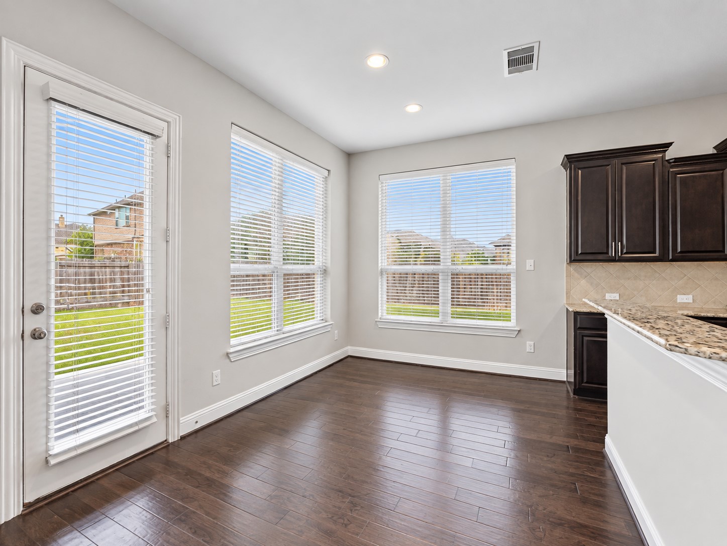 9626 Invergarry Way Tomball, TX 77375 - Photo 14 of 43 Breakfast area adjacent to the kitchen features wood flooring, multiple windows providing natural light, and direct access to the backyard.