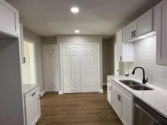 a kitchen with sink a refrigerator and cabinets