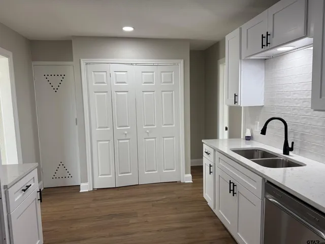 a kitchen with stainless steel appliances granite countertop a sink and wooden cabinets