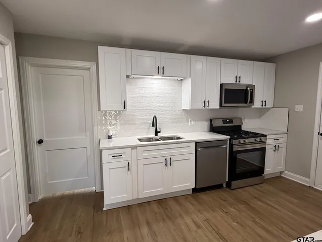 a kitchen with a sink and a stove top oven