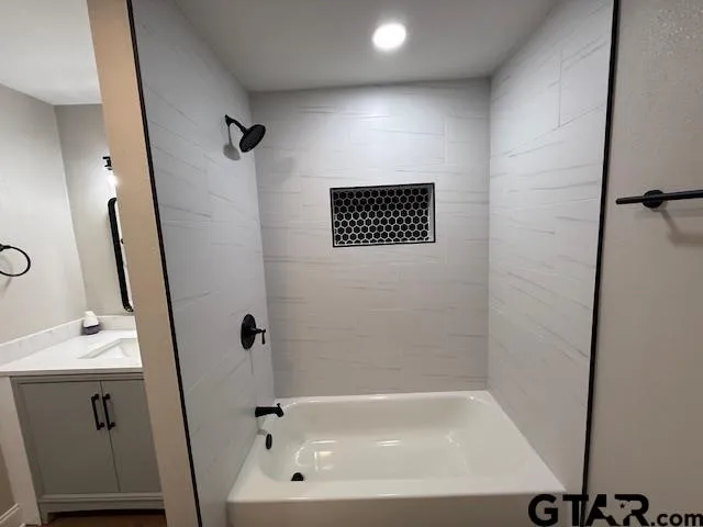a bathroom with a sink a bathtub and a mirror