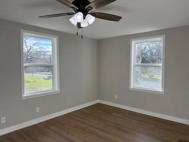 a view of an empty room with wooden floor