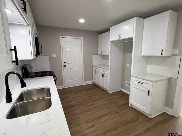 a kitchen with white cabinets sink and white appliances
