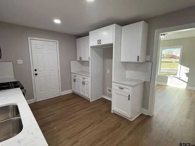 a kitchen with white cabinets and white appliances
