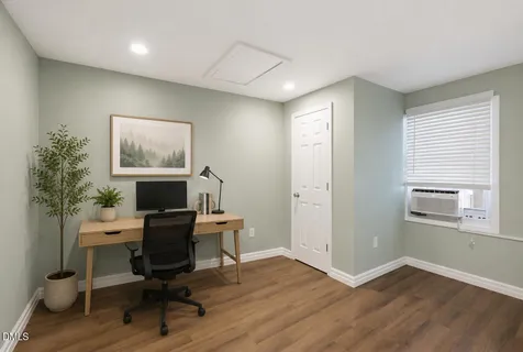 a view of a workspace with furniture and a window