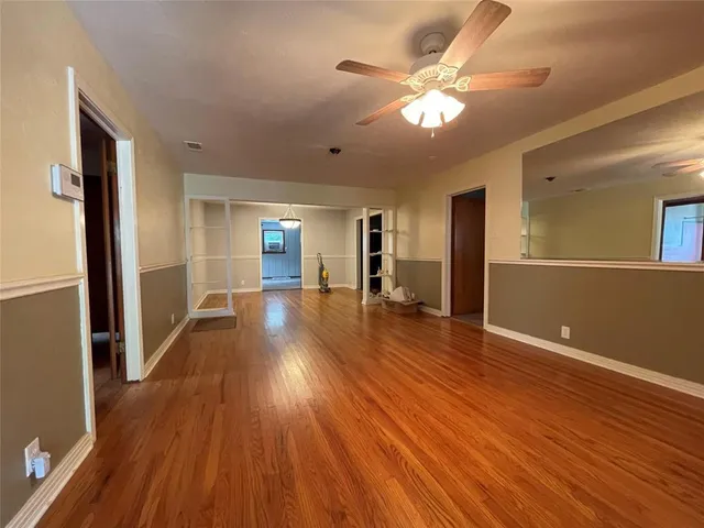 a view of a big room with wooden floor and a kitchen