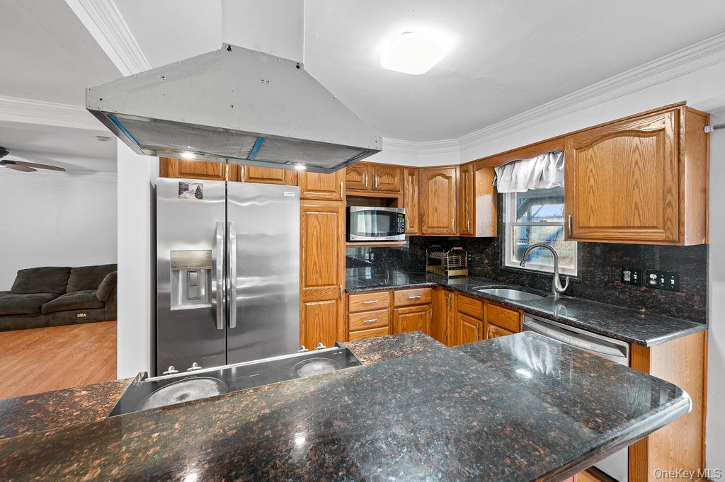 8 George Drive Mastic, NY 11950 - Photo 14 of 39 a kitchen with stainless steel appliances granite countertop a sink a stove and a refrigerator