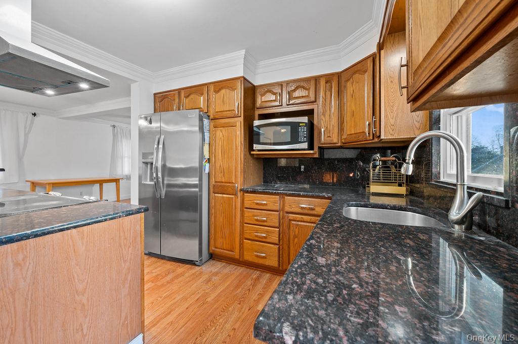 8 George Drive Mastic, NY 11950 - Photo 15 of 39 a kitchen with stainless steel appliances granite countertop a refrigerator a stove top oven a sink and dishwasher