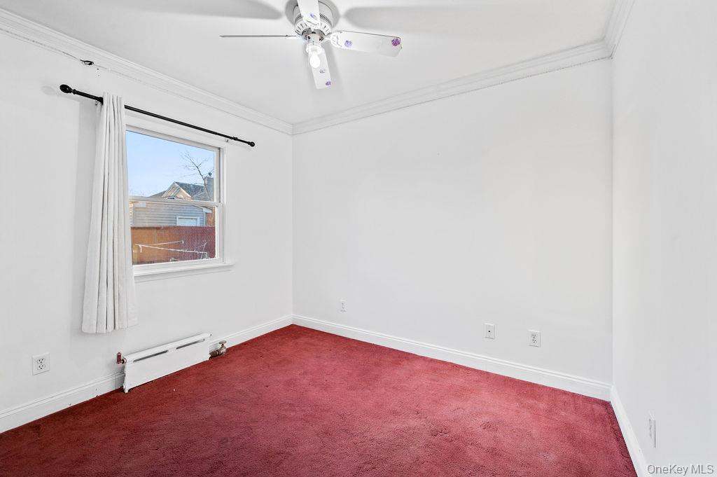 8 George Drive Mastic, NY 11950 - Photo 18 of 39 an empty room with a window and a chandelier fan
