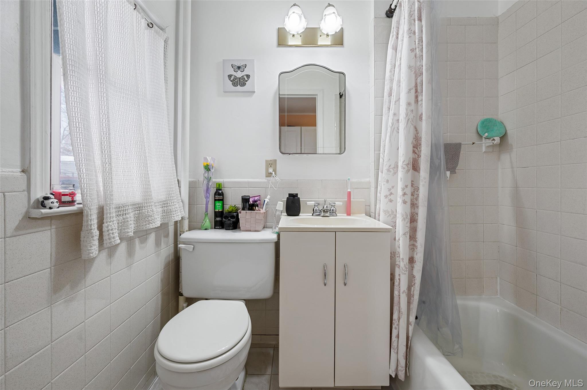 8 George Drive Mastic, NY 11950 - Photo 22 of 30 a bathroom with a sink a toilet and shower curtain