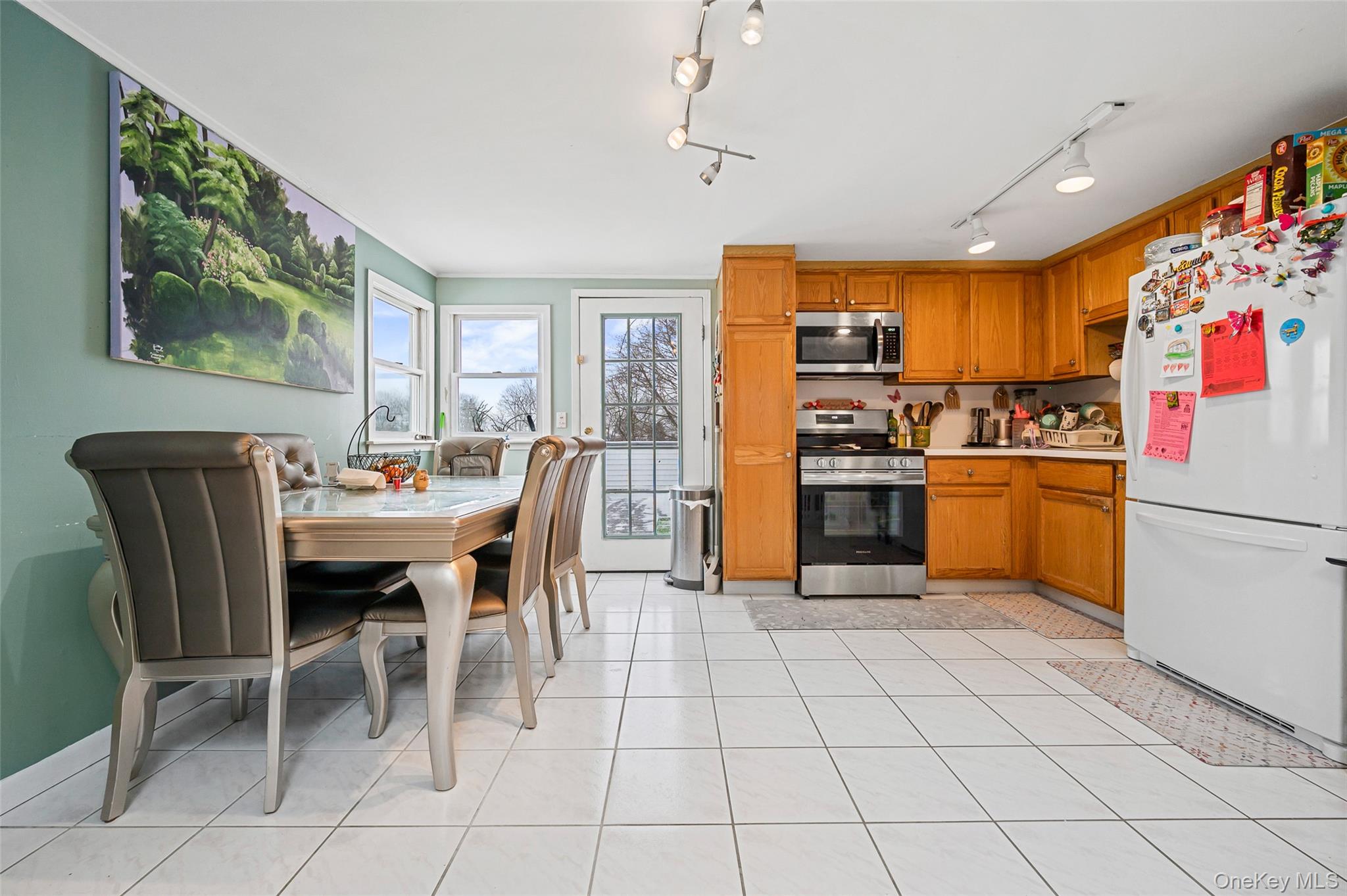 8 George Drive Mastic, NY 11950 - Photo 27 of 30 a kitchen with stainless steel appliances a stove a sink a dining table and chairs