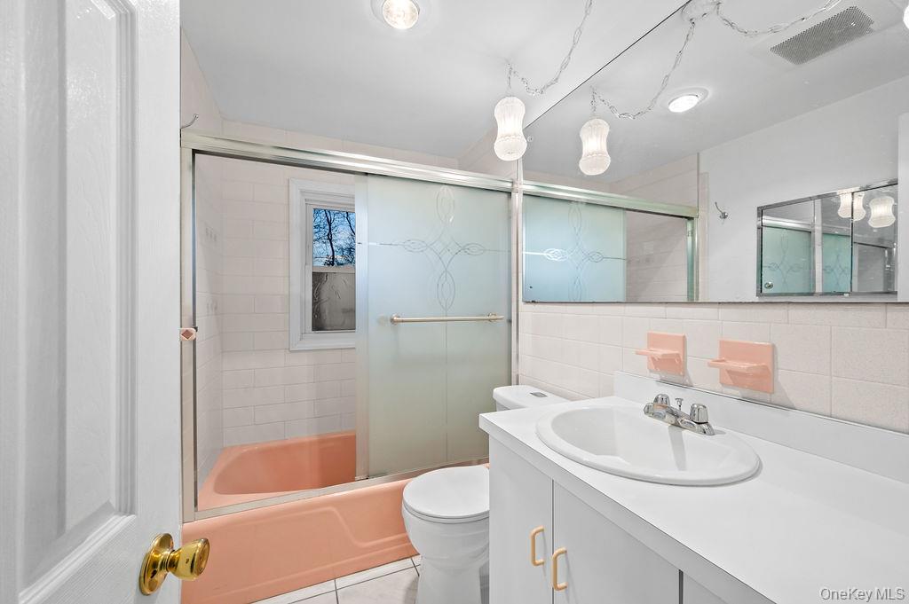 8 George Drive Mastic, NY 11950 - Photo 33 of 39 a bathroom with a sink a toilet a mirror and shower