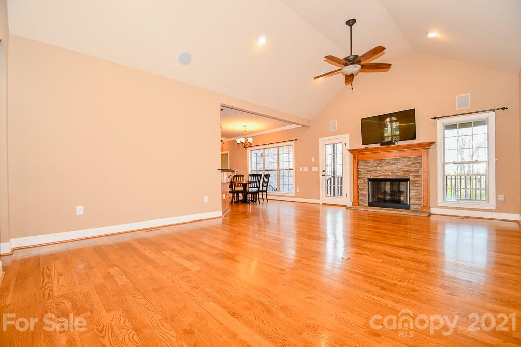 721 Roy Kindley Road Monroe, NC 28110 - Photo 11 of 32 a view of a livingroom with a fireplace a ceiling fan and wooden floor