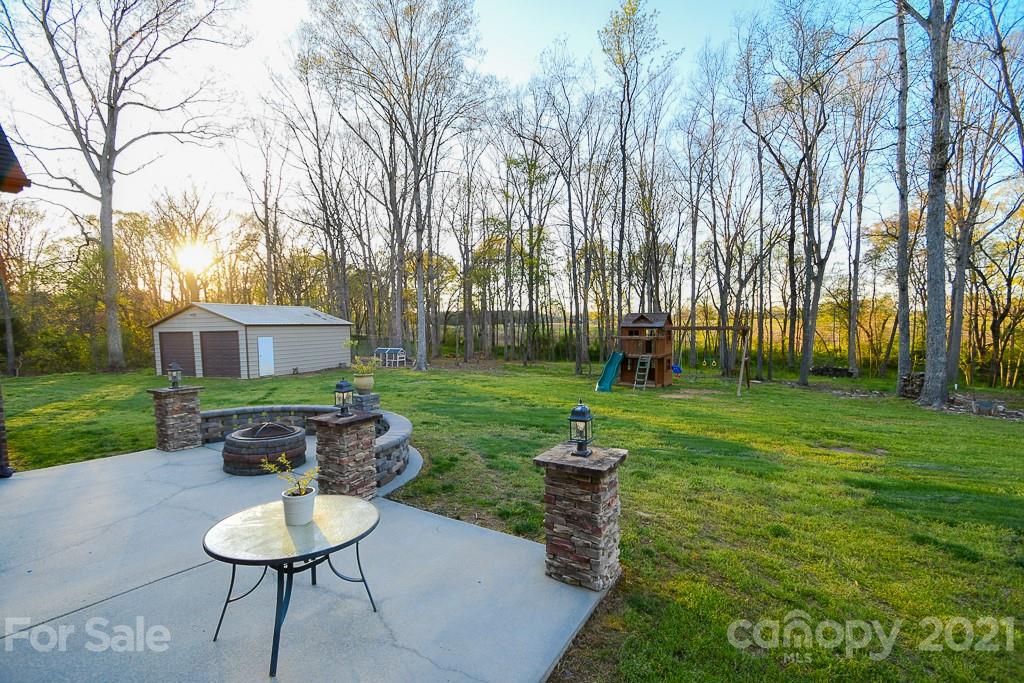 721 Roy Kindley Road Monroe, NC 28110 - Photo 6 of 32 a view of a backyard with table and chairs potted plants and a large tree