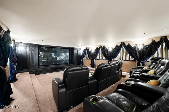 a bedroom with a large bed a chandelier and a mirror